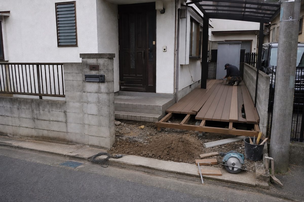 住宅の庭に面した出入り口で木のデッキを作る現場(AI・構成見本)