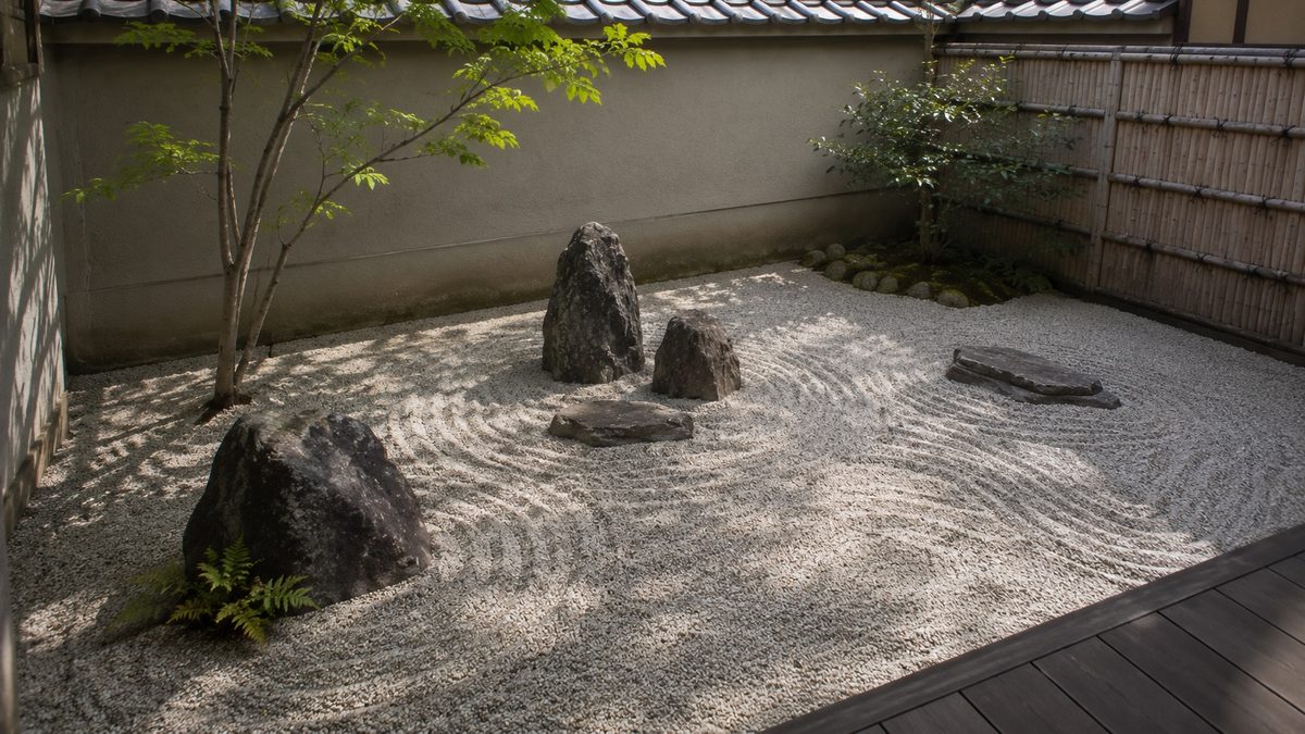 石と白砂の模様がある塀に囲まれた庭（AI・構成見本）