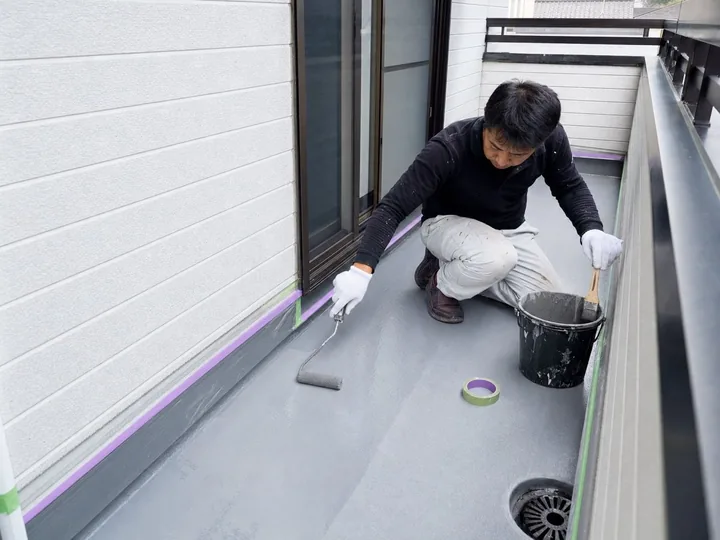 戸建て住宅のベランダ防水を施工する職人